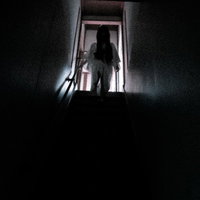 階段から見下ろす不気味な女性のシルエットの写真