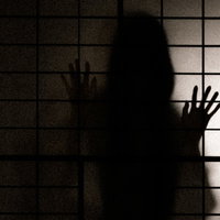 障子に映る女性のシルエット、中を覗こうとする姿の写真