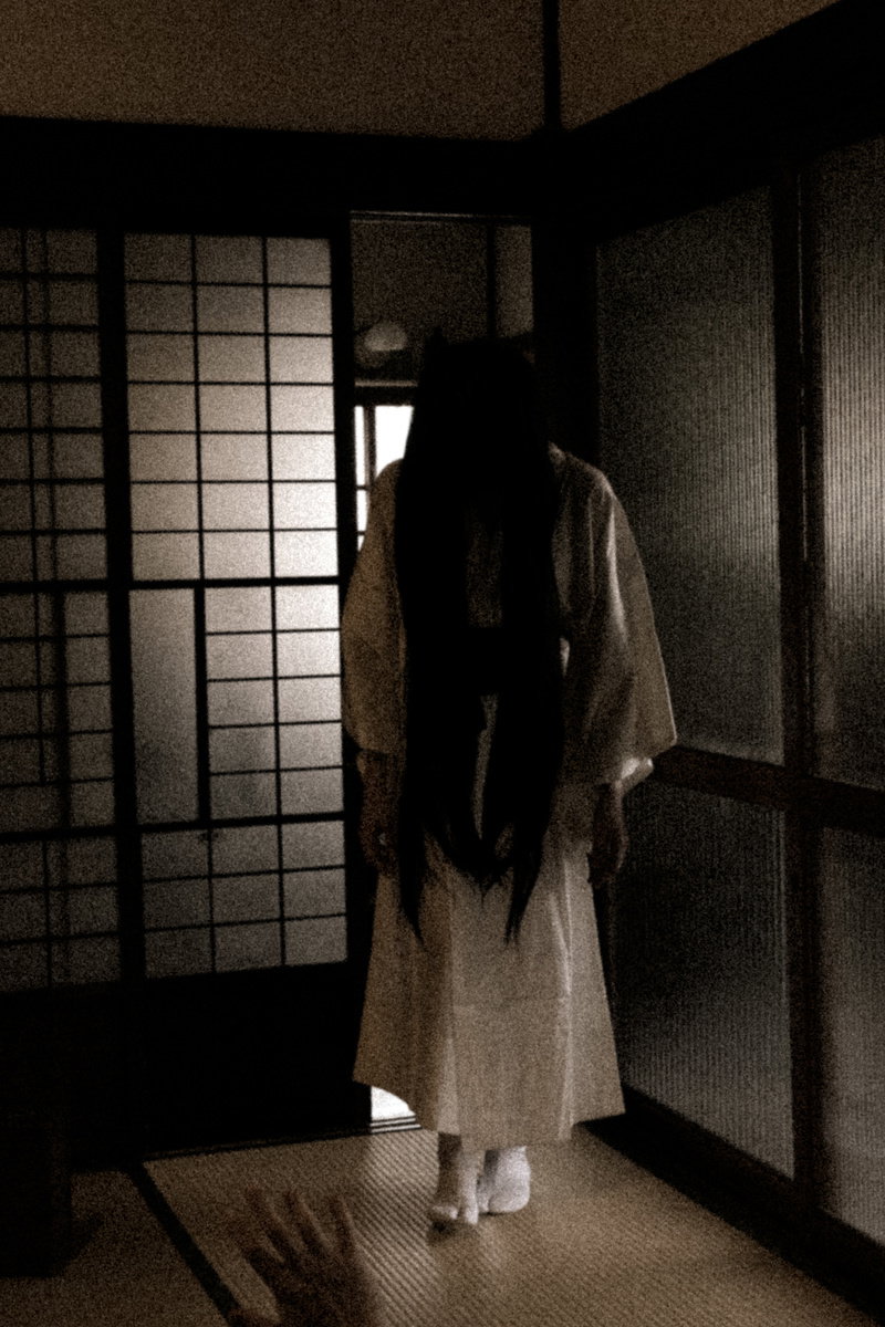薄暗い木造建築の廊下を白装束でゆっくりと歩く女性のシルエット［モデル：緋真煉］