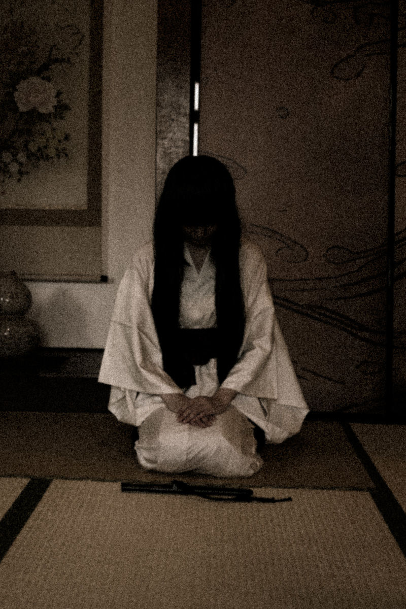 白装束の女性が薄暗い和室に正座［モデル：緋真煉］