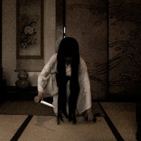 薄暗い和室で刃物を持った白い衣装の幽霊女性が現れたの写真