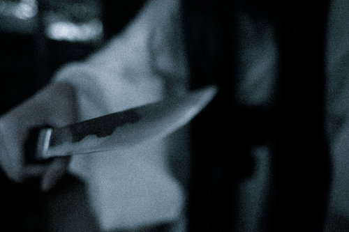 仇討ちに握りしめる短刀、暗い背景に浮かぶ復讐の手