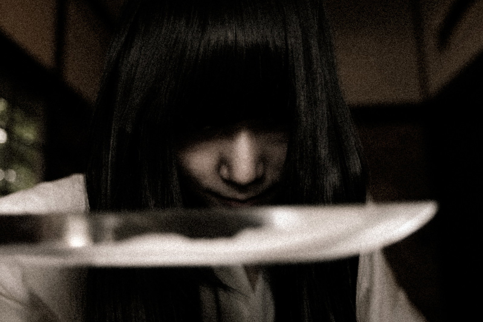 薄暗い部屋で刃物を持つ女性のホラーシーン［モデル：緋真煉］