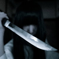 暗闇で包丁を握りしめる恐怖と恨みを抱く幽霊の写真