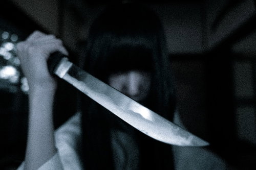 暗闇で包丁を握りしめる恐怖と恨みを抱く幽霊