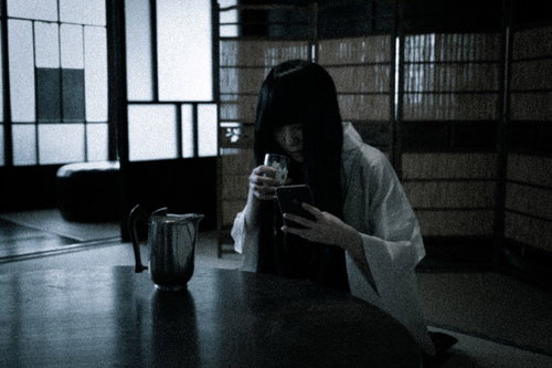 投稿を誰も見てくれず呪いたくなる女性、スマホを見つめる