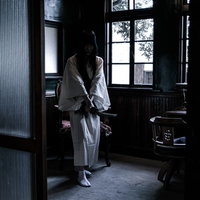 刀を振るう白装束の女性 恨みに満ちた表情で一刀両断の写真