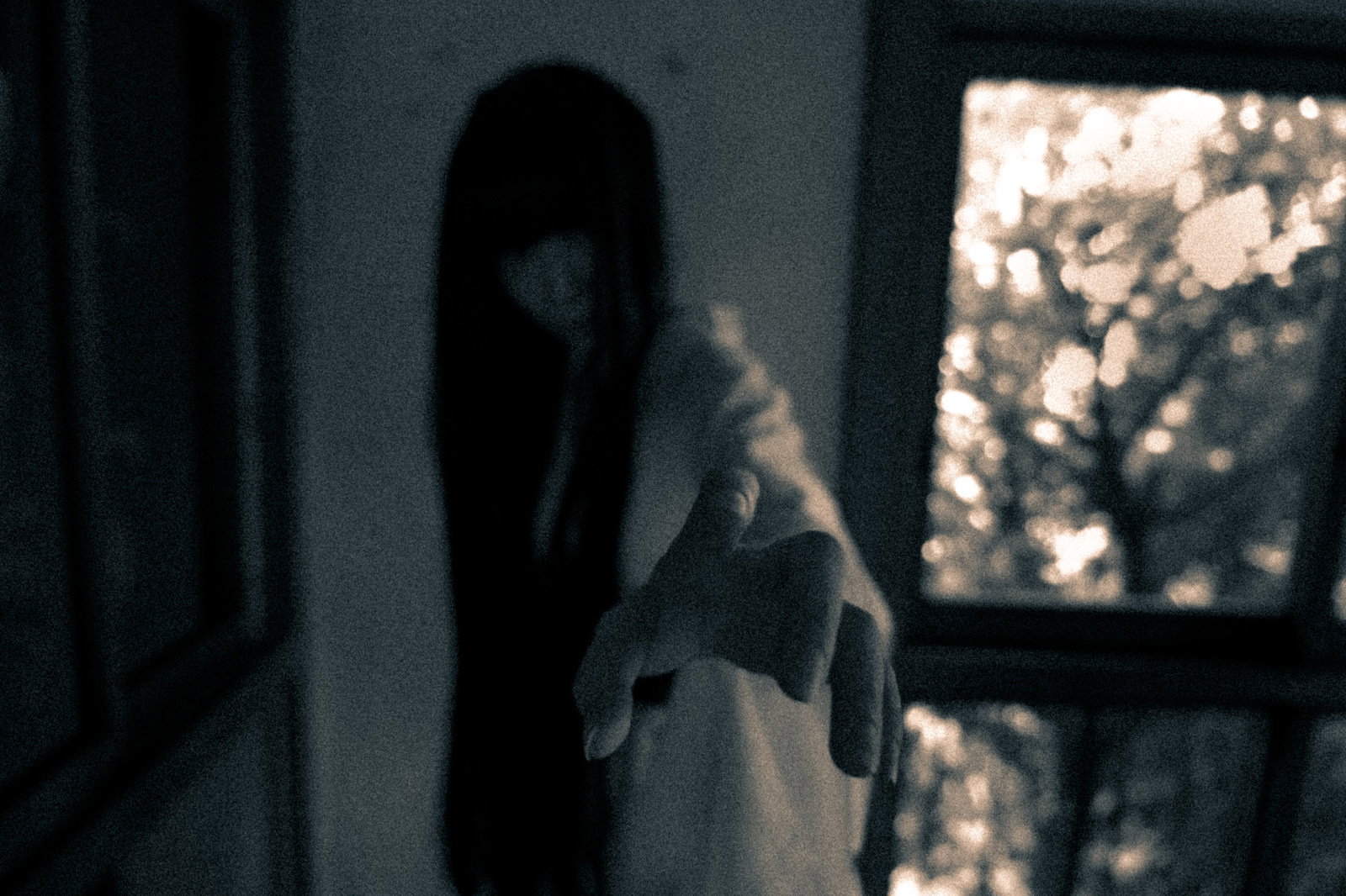 暗い部屋で両腕を伸ばす長い黒髪の幽霊［モデル：緋真煉］