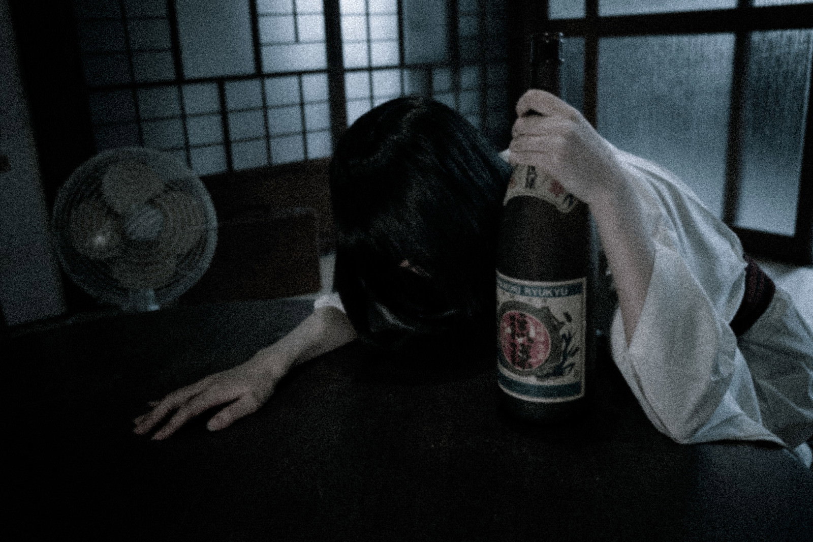和室で泡盛を掴んで突っ伏した黒髪の人物［モデル：緋真煉］