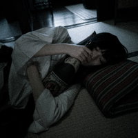 折りたたんだ座布団を枕にして眠る泥酔女子の写真