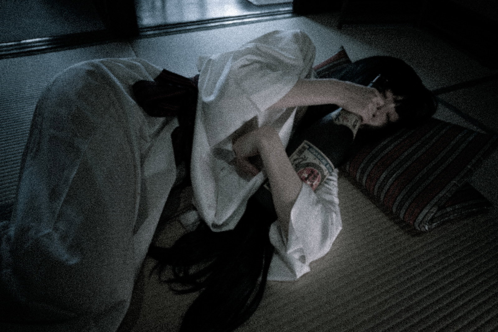 一升瓶を抱えて暗い場所で眠る白装束の女性［モデル：緋真煉］