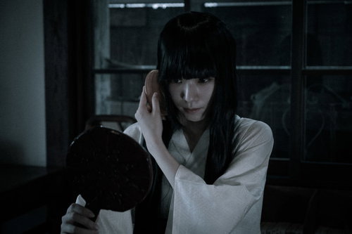 暗がりで髪をとかす不気味な女性の鏡の心霊現象