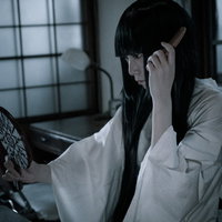 くしで髪をとく長髪幽霊の白い着物姿、暗い和室での写真