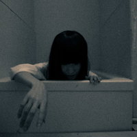 薄暗い風呂場の床から這い出る怨霊の女性の恐怖の写真