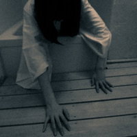 薄暗いお風呂場から這いずり出る女性の不気味な姿の写真