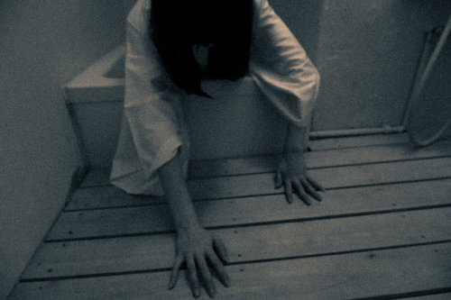 薄暗いお風呂場から這いずり出る女性の不気味な姿