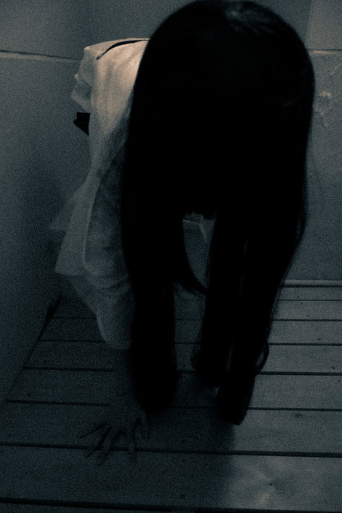 幽霊とその長く黒い髪 暗い室内で白い装束を身につけた怨霊