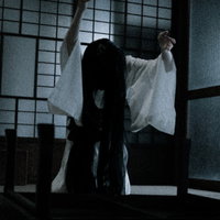 薄暗い和室でちゃぶ台をひっくり返すSADAKOの写真