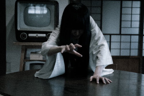 呪われた映像を見た後、テレビの前で這いつくばる女性