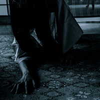 薄暗い廊下を這う長髪の女性｜お帰りなさいの写真