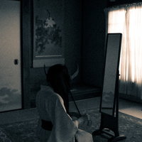 姿見鏡の前で正座して髪を解かす不気味な女性の写真