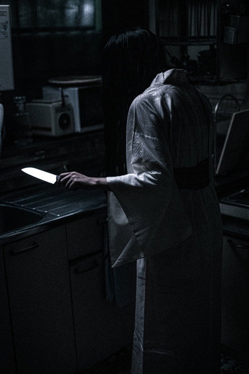 台所に立ち包丁を手にする不気味な女性の表情