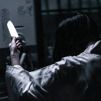 暗闇の中で包丁を握る異様な雰囲気での料理のはじまりの写真