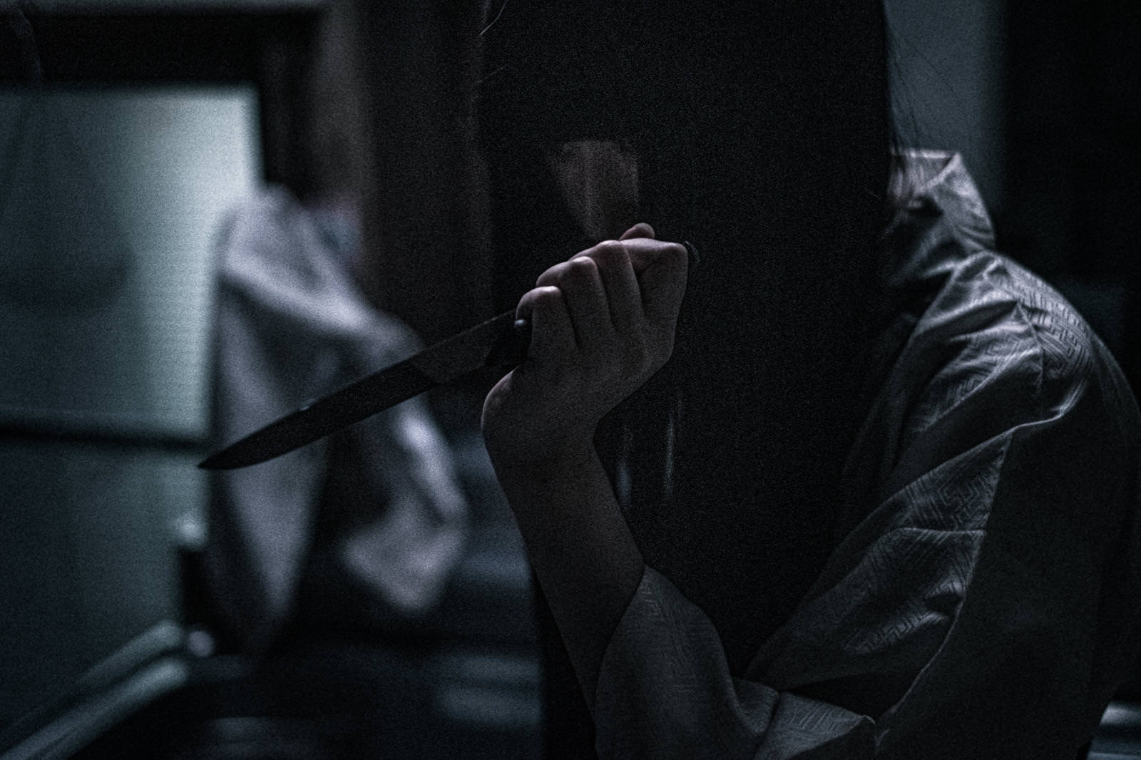 暗い空間で包丁を振りかざす女性の恐怖的なシーン［モデル：緋真煉］