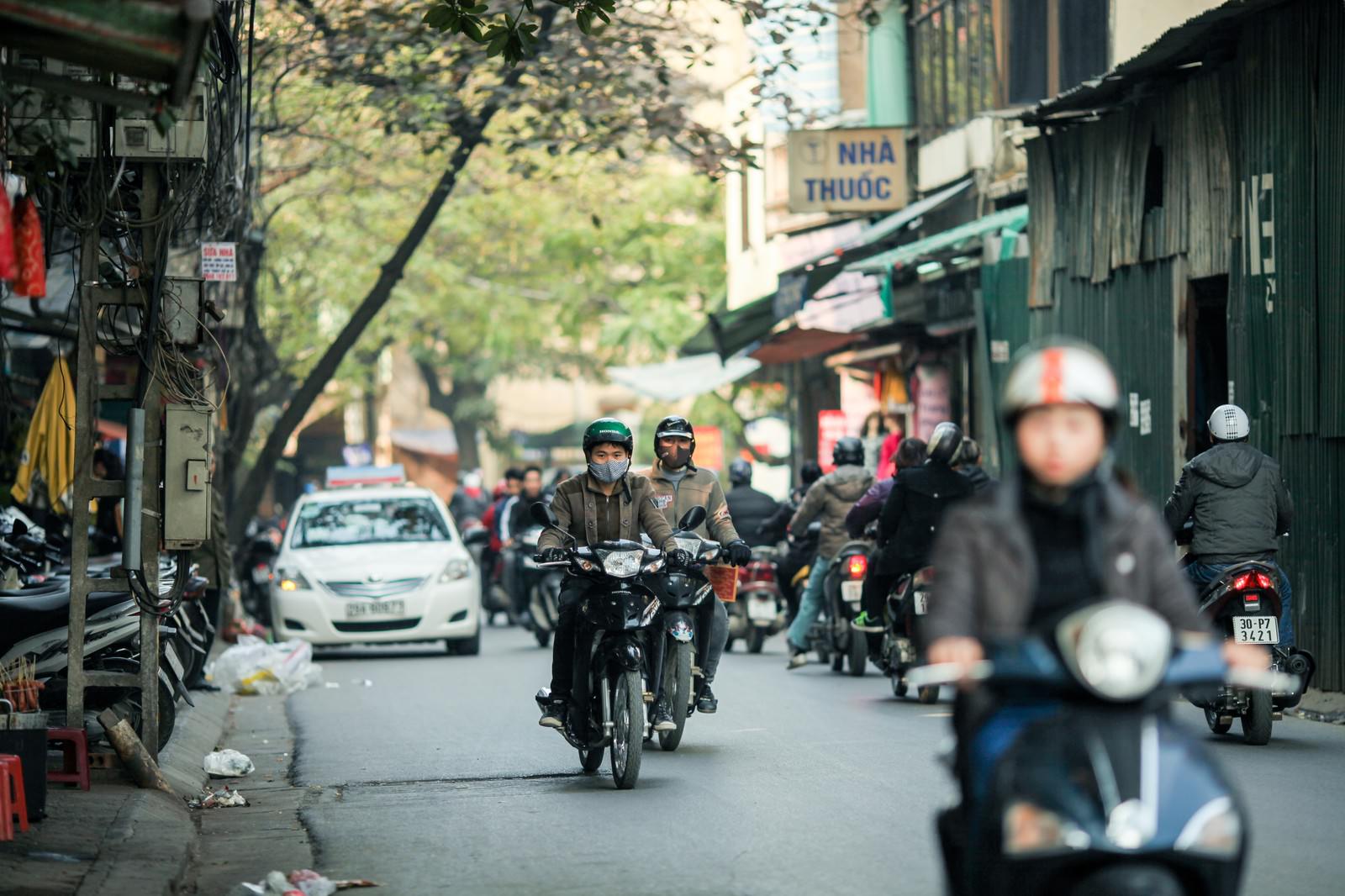 ハノイの街中の道路を多数のバイクが走行している風景