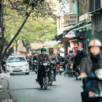 バイク文化の首都ハノイの街並み、多数のバイク走行と古い建物の写真