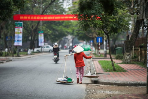 ベトナムの市街地で天秤棒を担ぐ女性の日常風景
