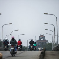 フエの世界遺産へ続く街灯沿いの道をバイクで走行の写真