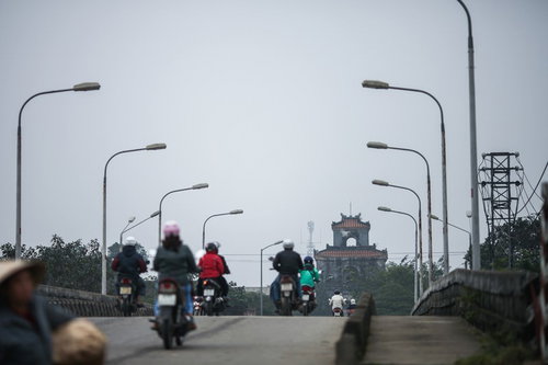 フエの世界遺産へ続く街灯沿いの道をバイクで走行