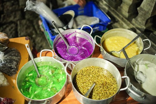 川沿いに立ち並ぶ大型看板とゴミが散乱するホーチミンの空き地