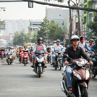 ホーチミンの市街地を走行するバイク集団と交通風景の写真