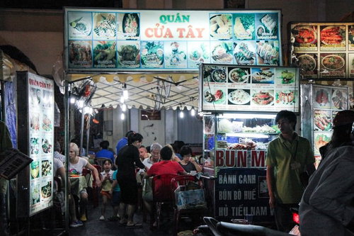 ベトナムの屋台村で食事を楽しむ地元の人々と活気ある調理風景