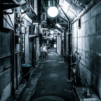 夜の路地裏に浮かぶ円形灯りの写真