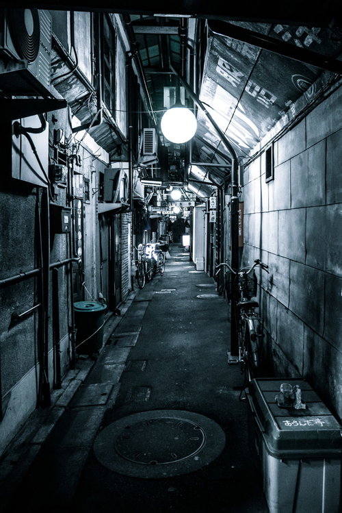 夜の路地裏に浮かぶ円形灯り