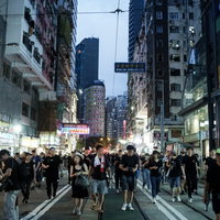 夜の香港の路上を歩く大勢の人達の写真