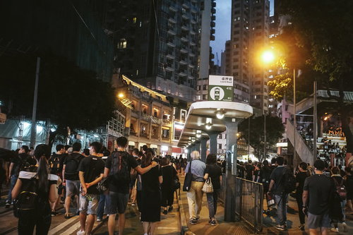 香港の夜間路上で黒装束の群衆が歩くデモ行進