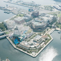 横浜みなとみらいの観覧車と港湾施設の空撮の写真