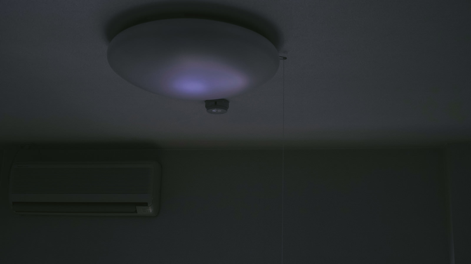 暗い部屋でうっすら青白く光るシーリングライト