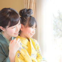 温泉旅館の客室でゆったり寛ぐ親子が庭先を眺めるの写真