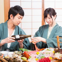 温泉旅館の舟盛りで記念日をお祝いするふたりの写真