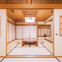 畳に低い木製テーブルと障子戸や棚がある離れの和室の写真
