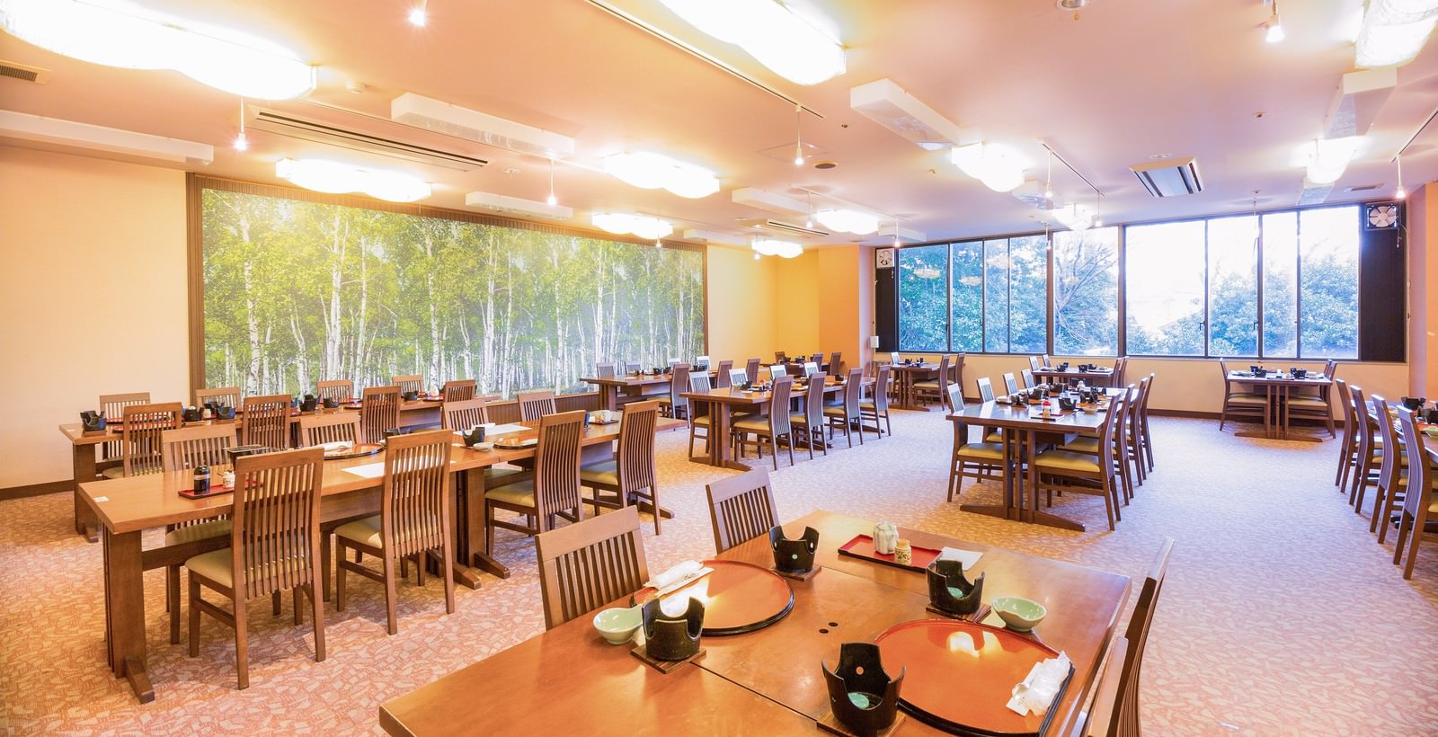 光が入る食事会場に並ぶテーブルと急須