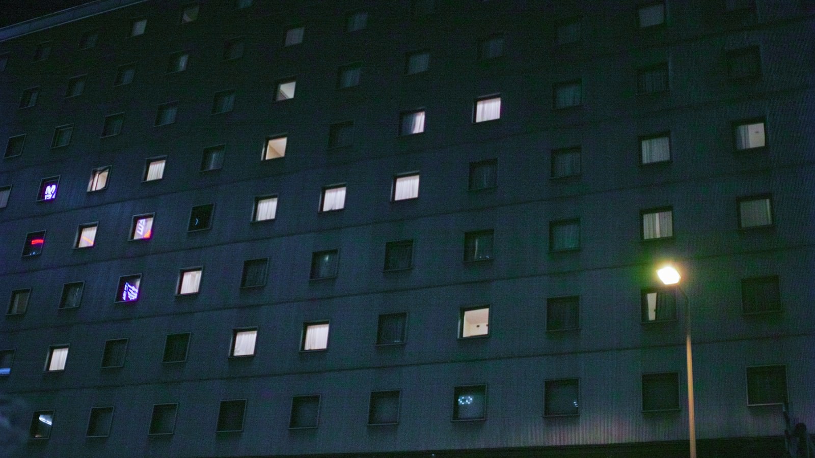 夜間に一部の窓が灯る高層ビルの外観