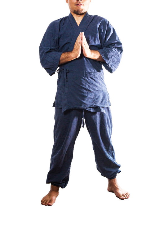 紺色の道着に袖を通し合掌する男性の礼儀作法