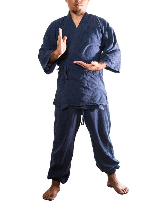 作務衣を着て真顔で大仏ポーズをとる男性