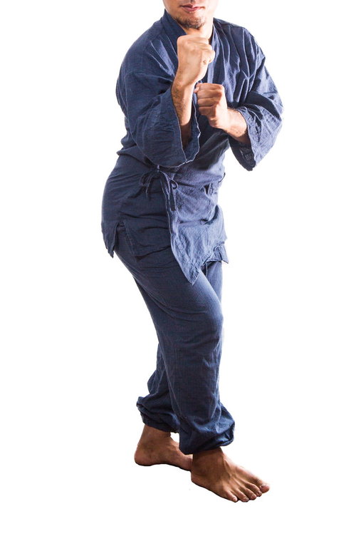 紺色の柔道着を身にまといファイティングポーズをとる男性